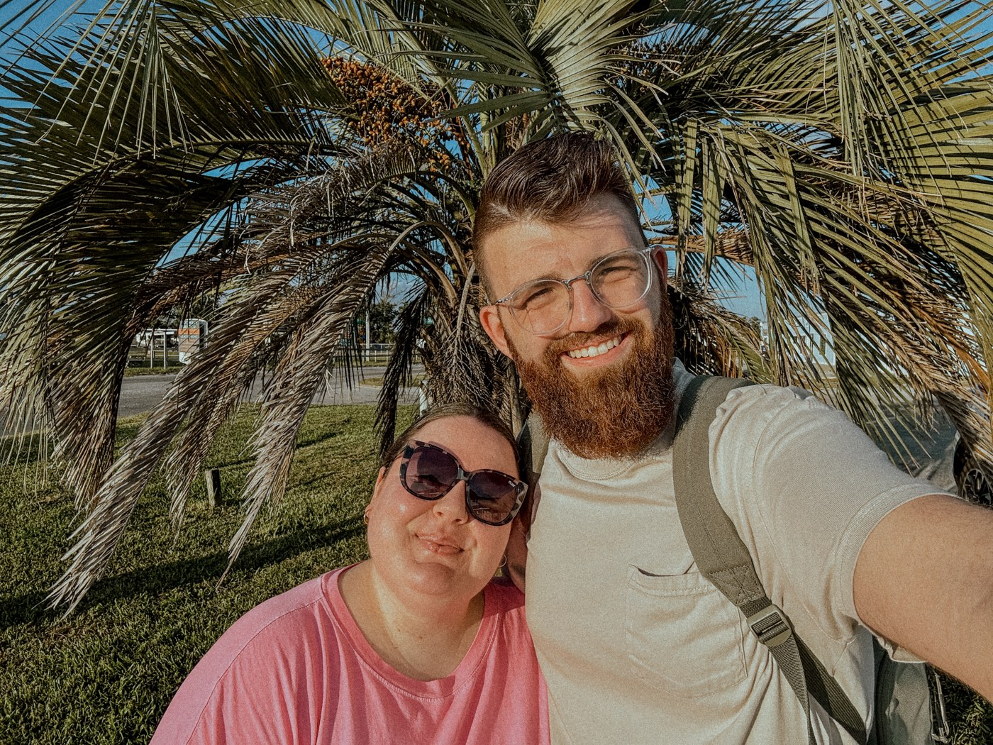Austin and Sarah under a palm at golden hour